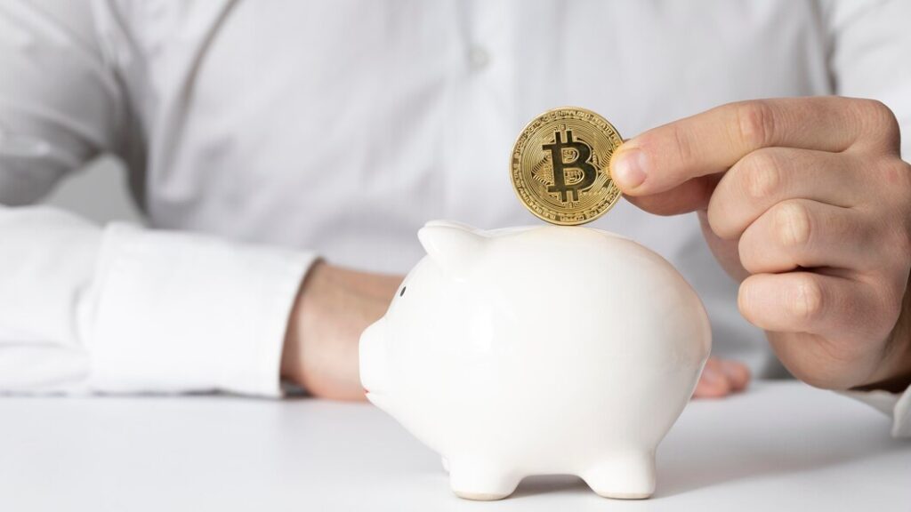 man-inserting-bitcoin-piggy-bank_23-2148793770